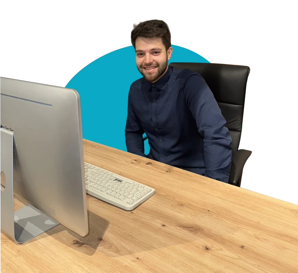 TourDent dental travel coordinator smiling at office desk with computer