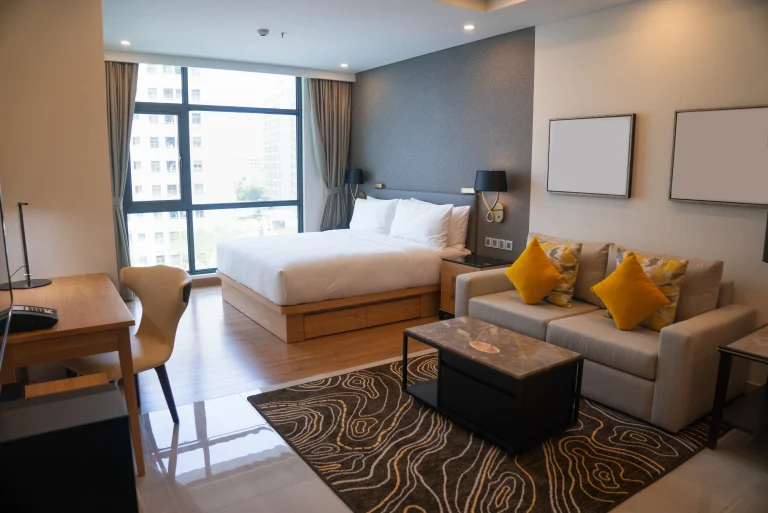 TourDent partner hotel modern studio room with king bed, sofa and city view window