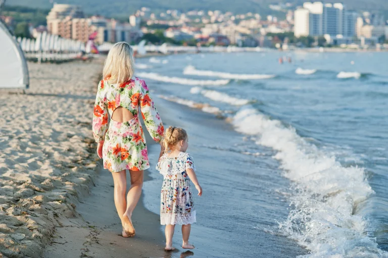 TourDent dental holiday — mother and daughter walking along the beach after dental treatment abroad