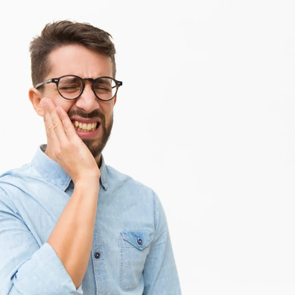 Man suffering from severe toothache holding cheek in pain — dental treatment needed